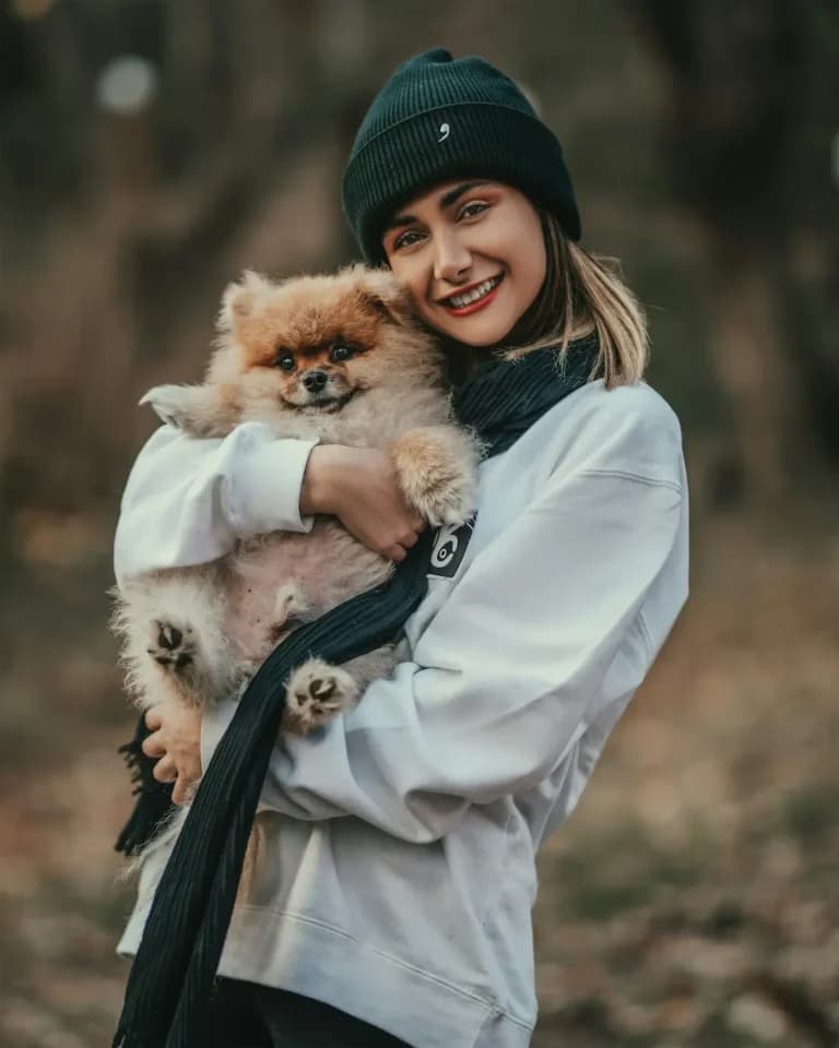 Owner holding emotional support dog outdoors