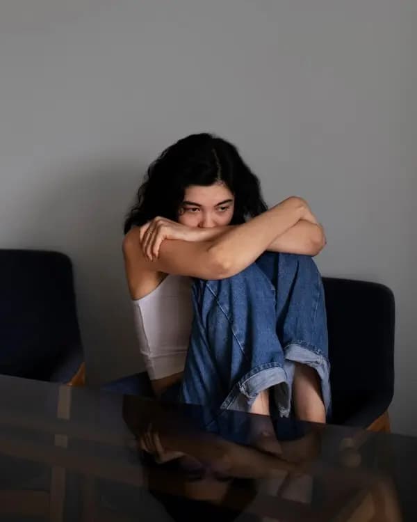 Person seated, reflecting in a quiet moment